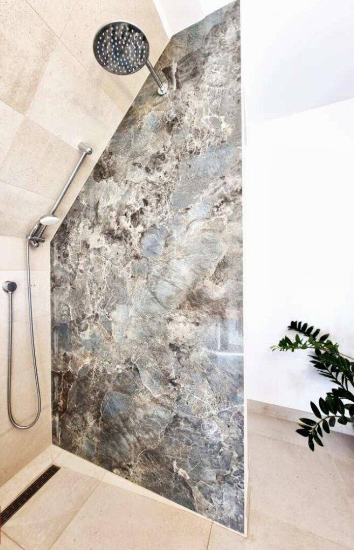 Moderne begehbare Dusche mit stilvoller Marmoroptik-Wand und Regenduschkopf.