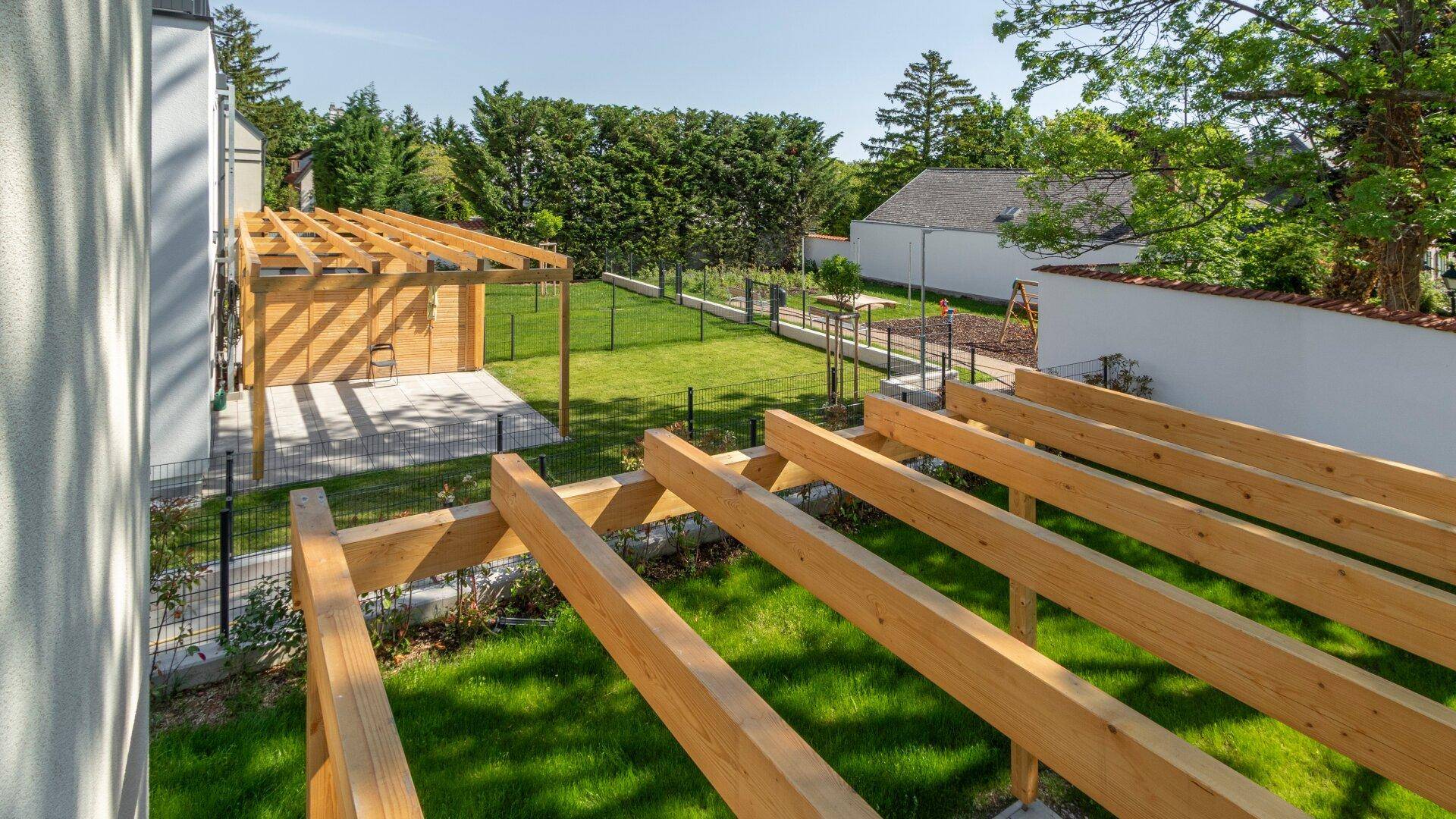 Weitläufiger Gartenbereich mit mehreren Holzpergolen und viel Grünfläche für Erholung und Freizeit.