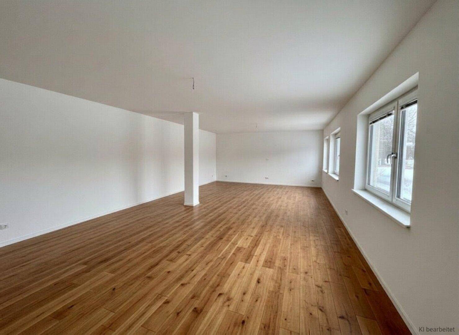 Geräumiger, leerer Raum mit Holzboden und großen Fenstern, ideal für Büronutzung.