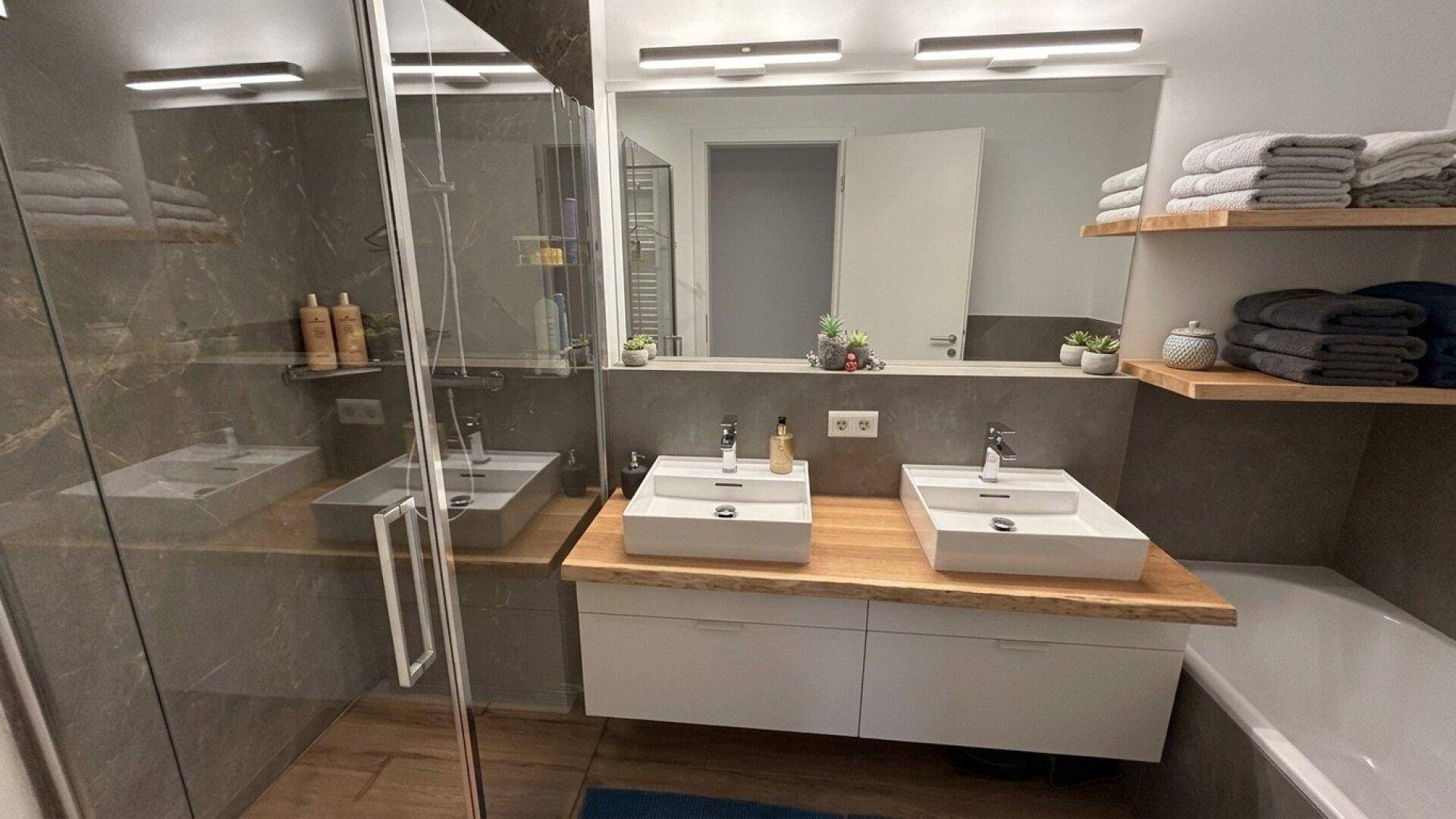 Geräumiges modernes Badezimmer mit Doppelwaschbecken, Badewanne und begehbarer Dusche.