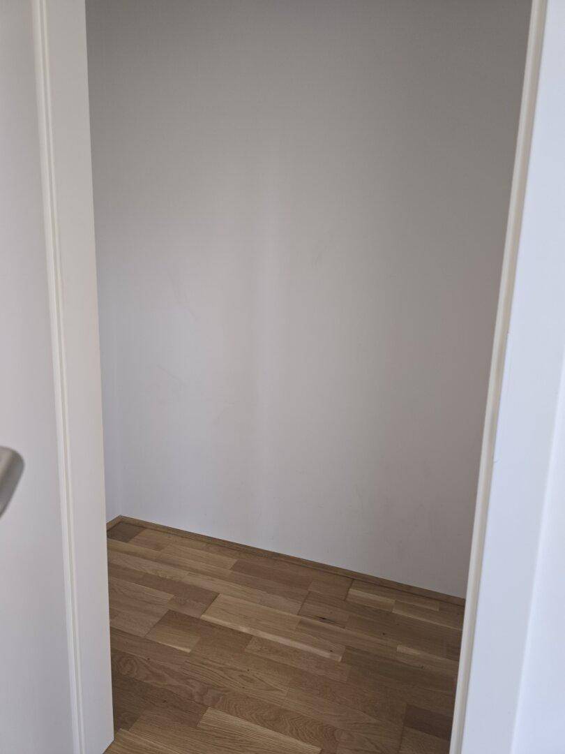 Kleiner Abstellraum mit Holzfußboden, ideal für zusätzlichen Stauraum im Haushalt.