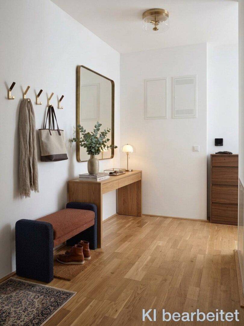 Heller Eingangsbereich mit Holzfußboden, Spiegel und praktischer Garderobe für den Empfang.