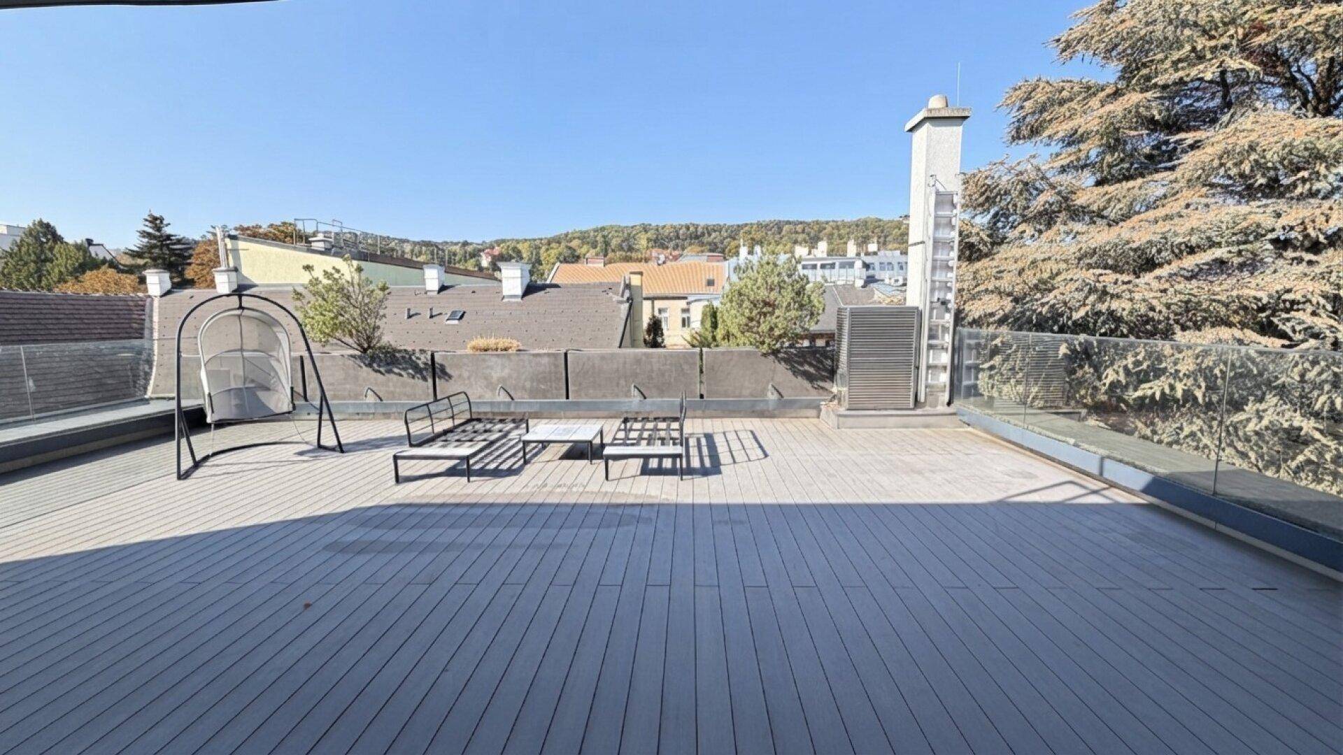 Große Dachterrasse mit Sitzgelegenheiten und weitem Blick über die Dächer der Stadt.
