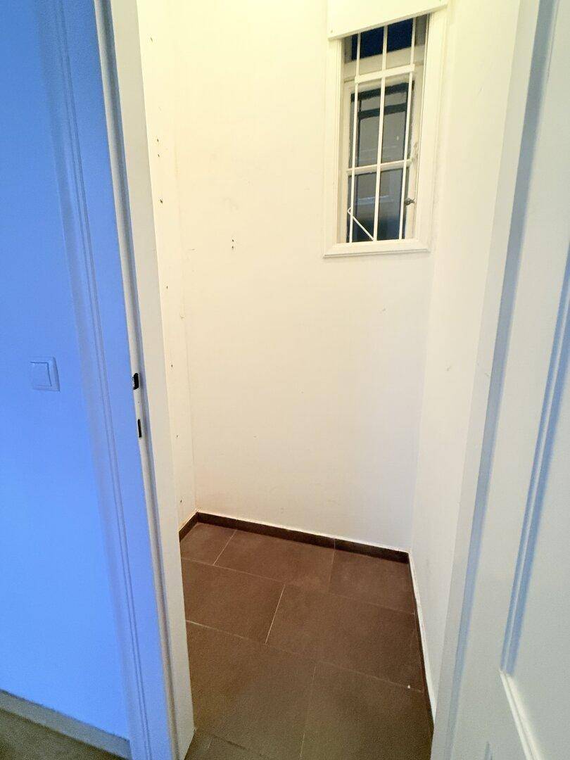 Kleiner Abstellraum mit Fliesenboden und Fenster, ideal für zusätzlichen Stauraum.
