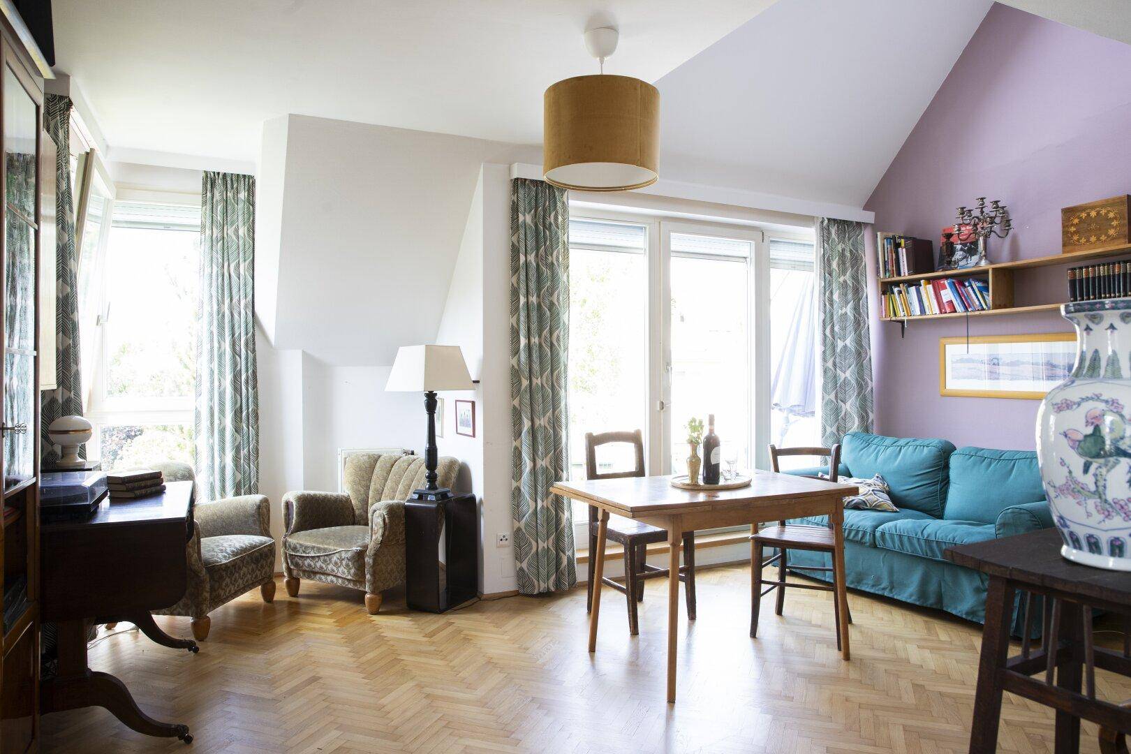Geräumiger Wohn-Essbereich mit Esstisch, Sofa, Sesseln und großen Fenstern für viel Tageslicht.
