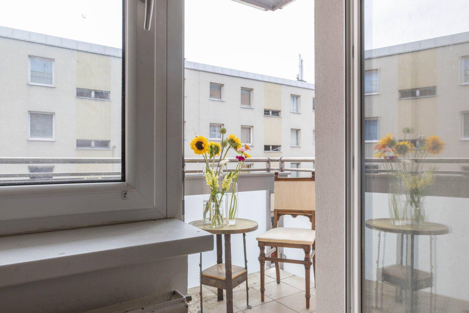 Balkon mit Sitzgelegenheiten und Blick auf die umliegenden Gebäude.
