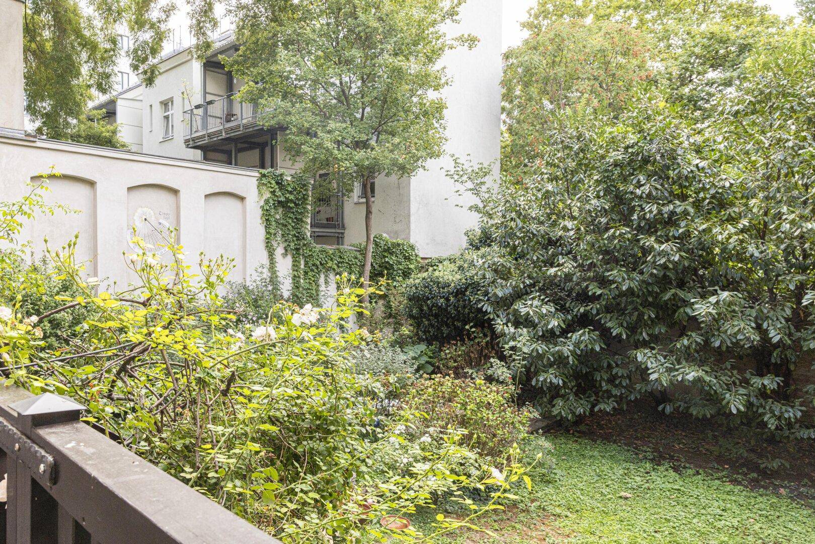 Üppiger, grüner Garten mit verschiedenen Pflanzen und Bäumen, der eine ruhige und natürliche Umgebung bietet.