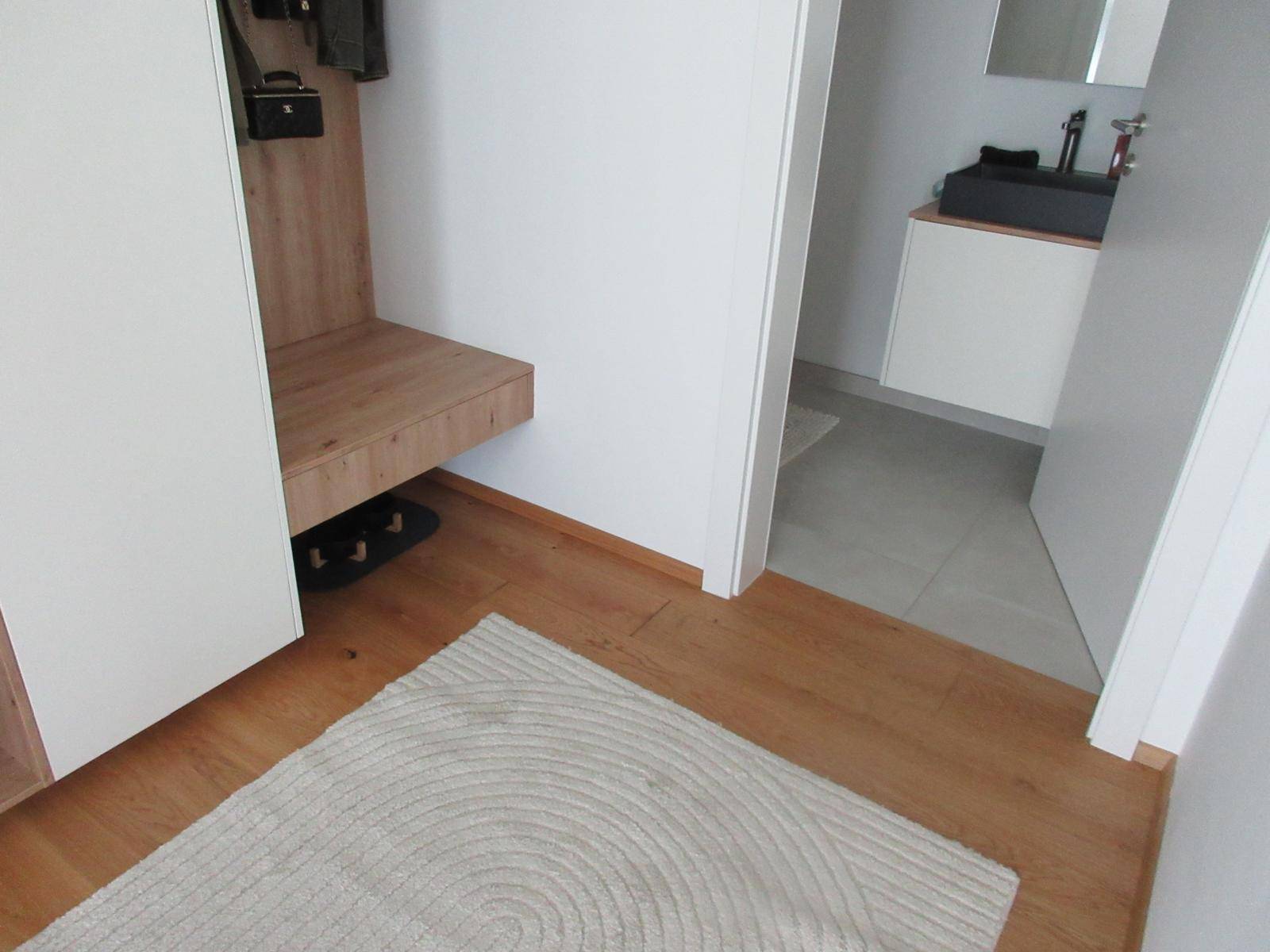 Heller Flur mit Holzboden und integrierter Garderobe.
