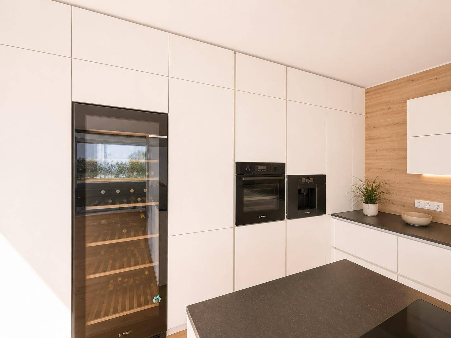 Moderne Einbauküche mit integrierten Geräten, Weinkühler und Holzdetails.