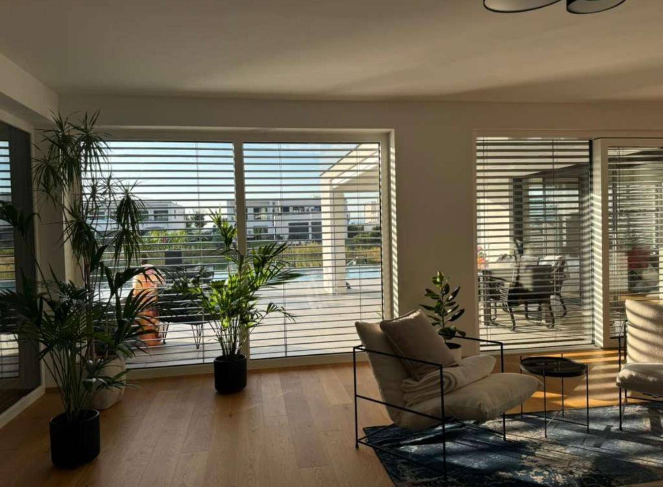Wohnzimmer mit großen Fenstern, die einen weiten Blick auf die Umgebung bieten.