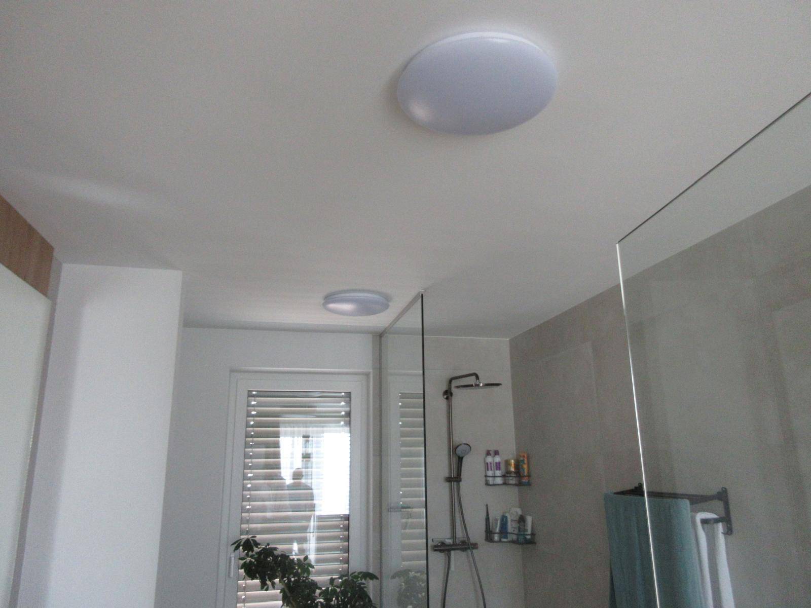 Deckenansicht in einem modernen Badezimmer mit integrierten Leuchten.