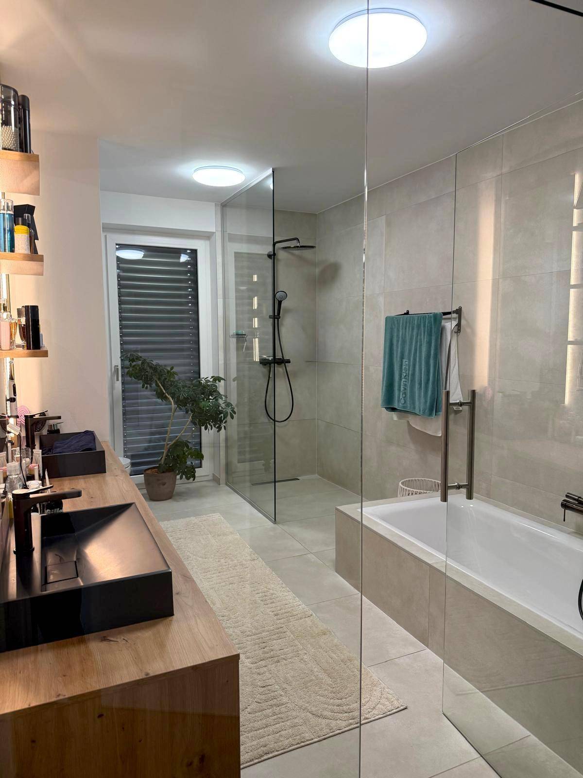 Modernes Badezimmer mit Doppelwaschbecken, begehbarer Dusche und Badewanne.