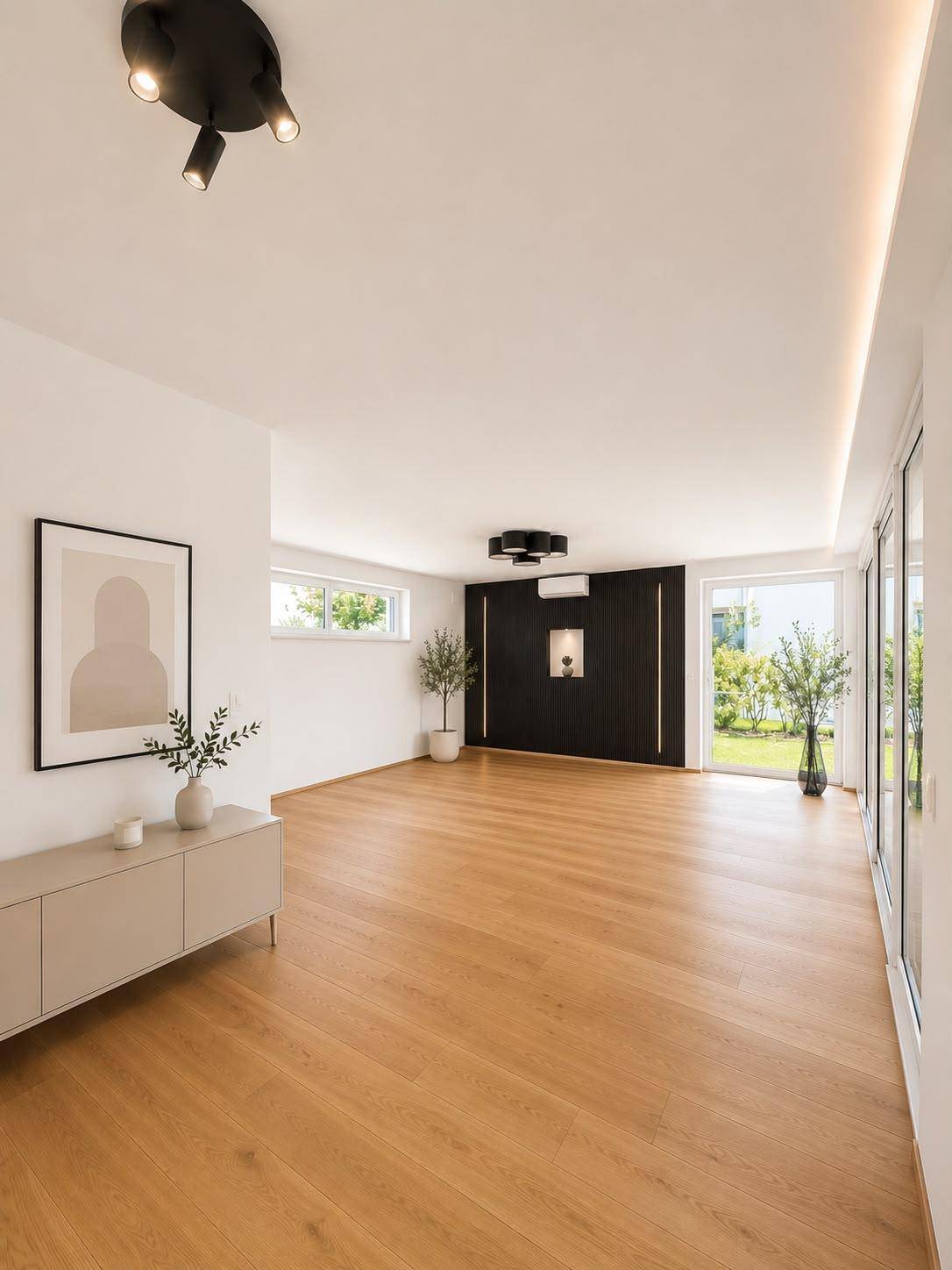 Geräumiges Wohnzimmer mit Holzboden, großen Fenstern und Zugang zum Garten.