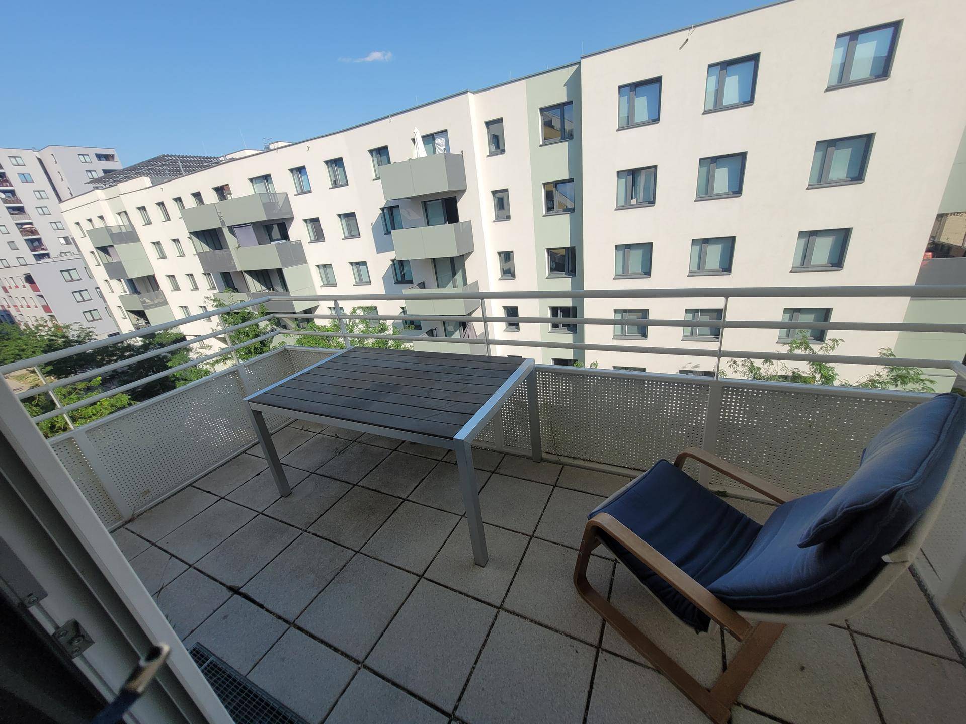Geräumiger Balkon mit Tisch und Stuhl, ideal für entspannte Stunden im Freien.