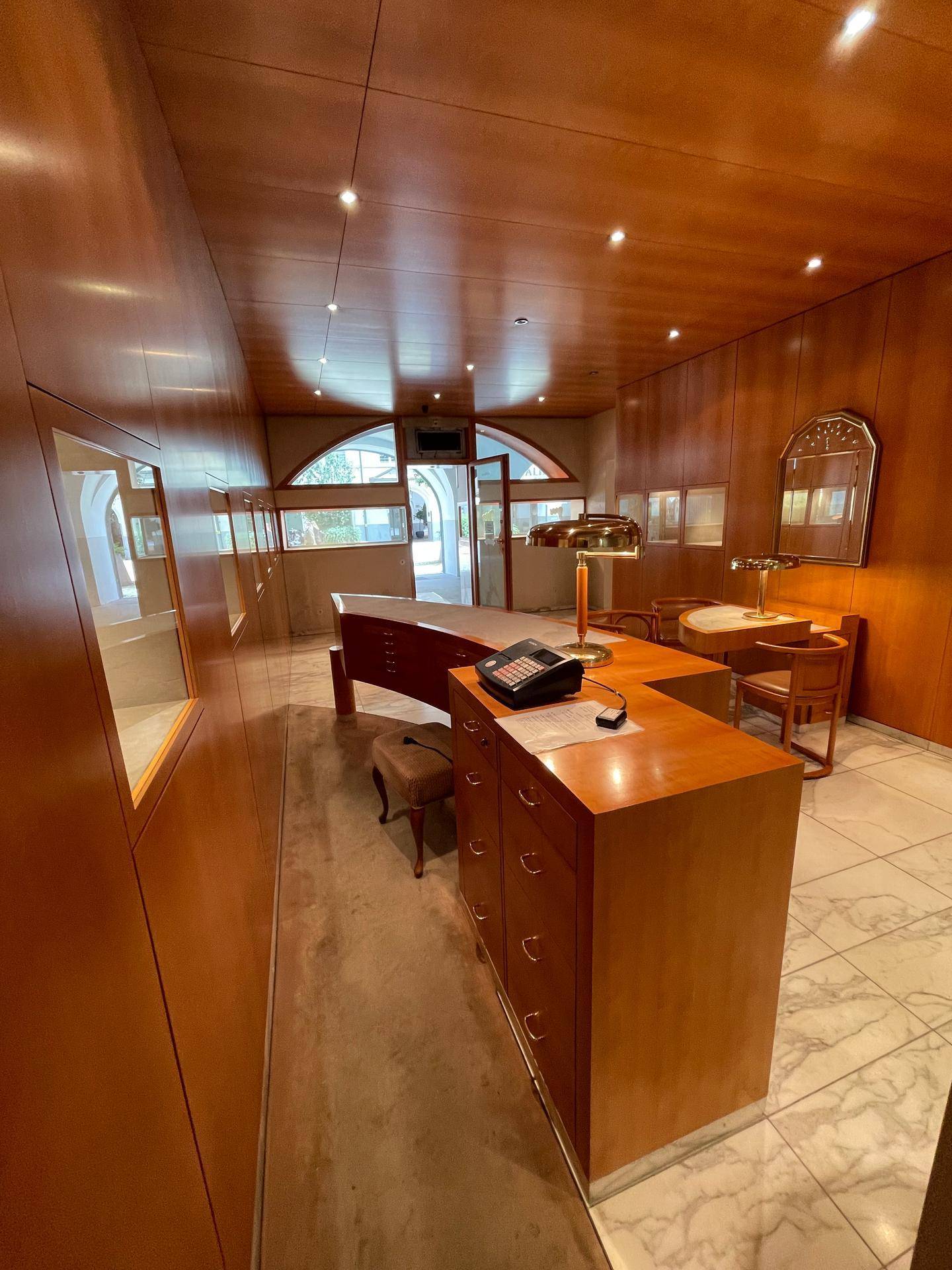 Detailansicht des Verkaufsraums mit Holztresen, Telefon und weiteren Präsentationsmöglichkeiten.