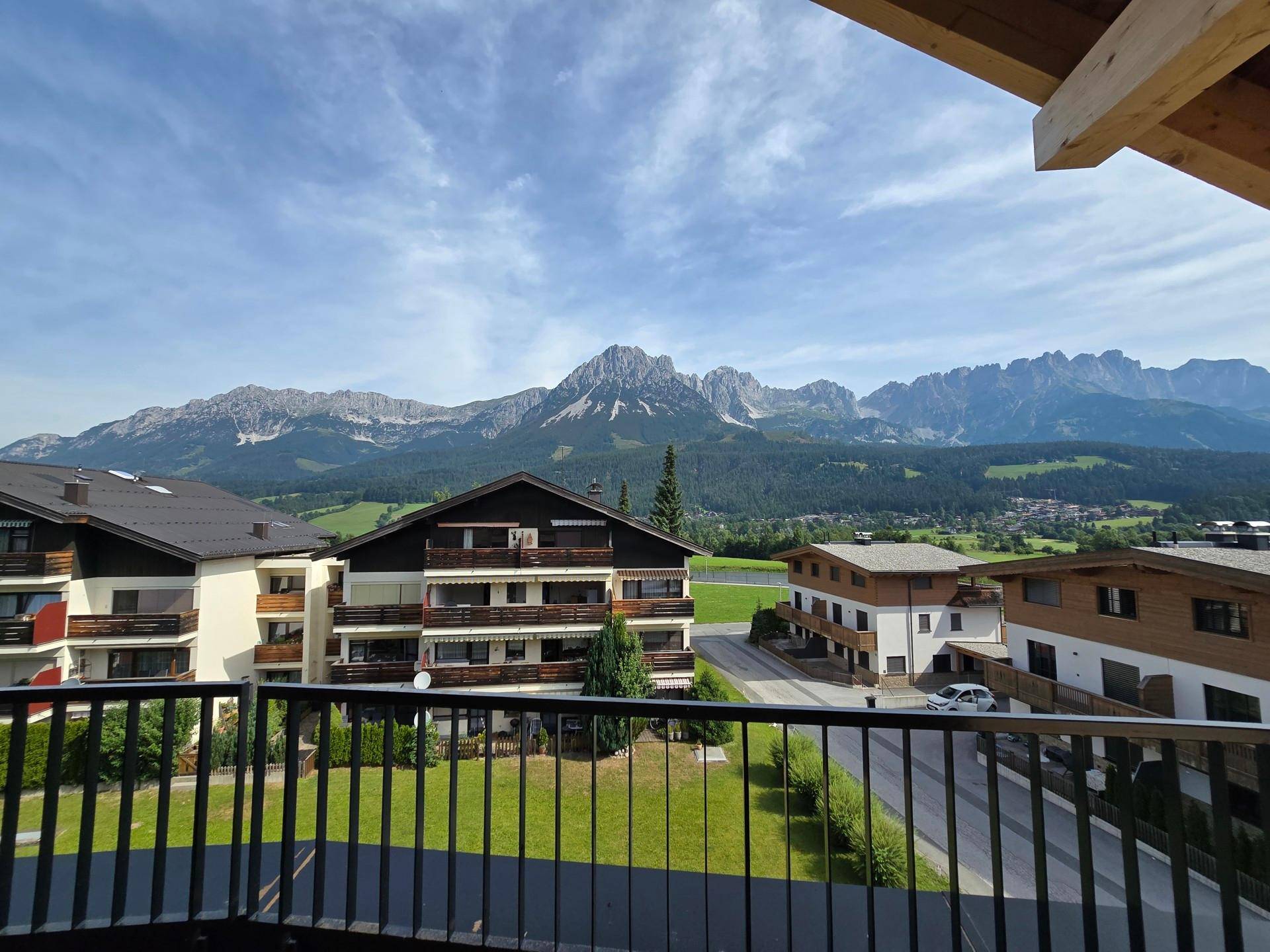 Panoramablick vom Balkon auf die majestätische Bergkette und die umliegende grüne Landschaft.