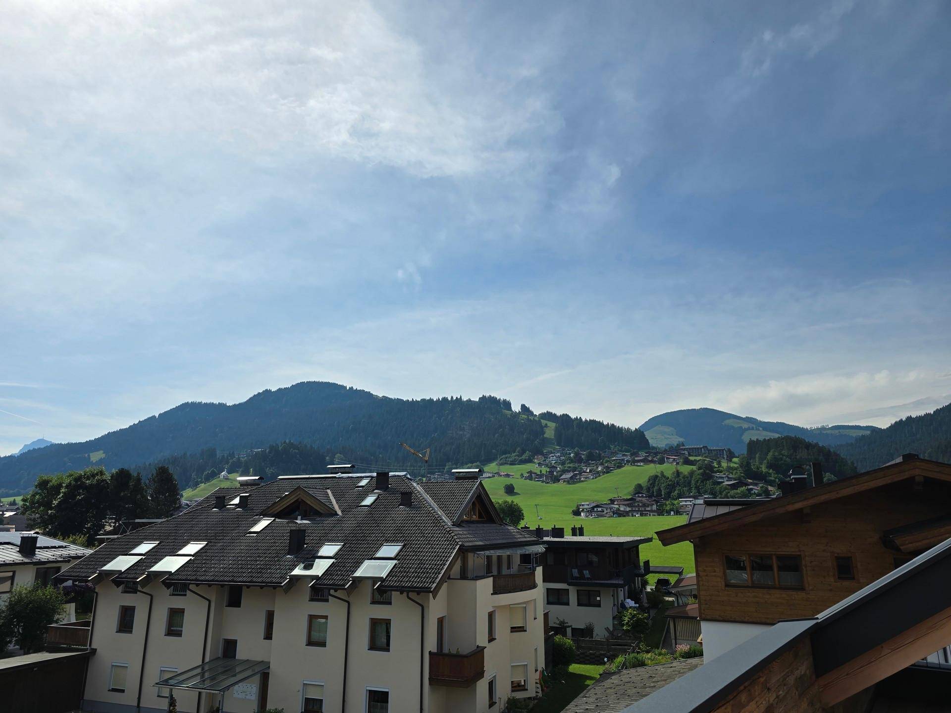 Weitblick über die grünen Hügel und die Dächer der umliegenden Häuser unter blauem Himmel.