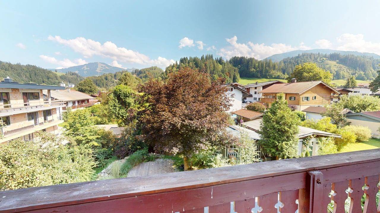 Weitläufiger Blick vom Balkon auf die umliegende Berglandschaft und grüne Täler.