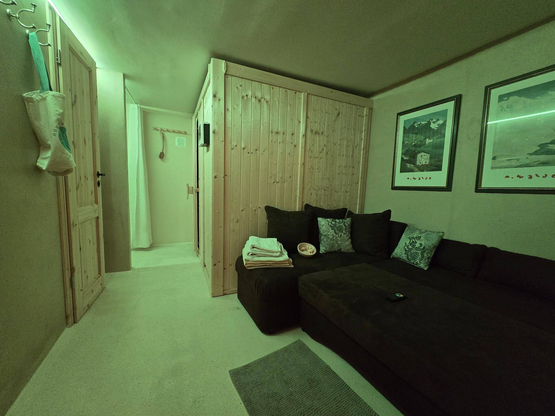 Entspannungsbereich mit Sauna und gemütlicher Sitzecke, ideal für Wellness zu Hause.