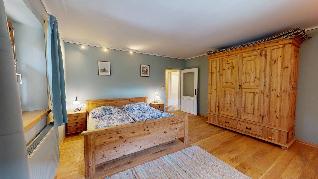 Gemütliches Schlafzimmer mit Holzmöbeln, Doppelbett und hellem Holzboden, einladende Atmosphäre.