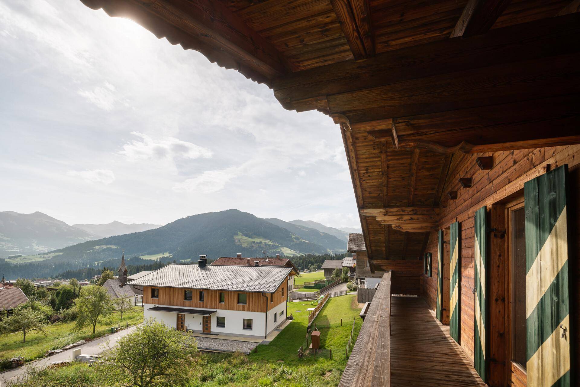 Geräumiger Holzbalkon mit weitem Blick über das Tal und die umliegende Berglandschaft.