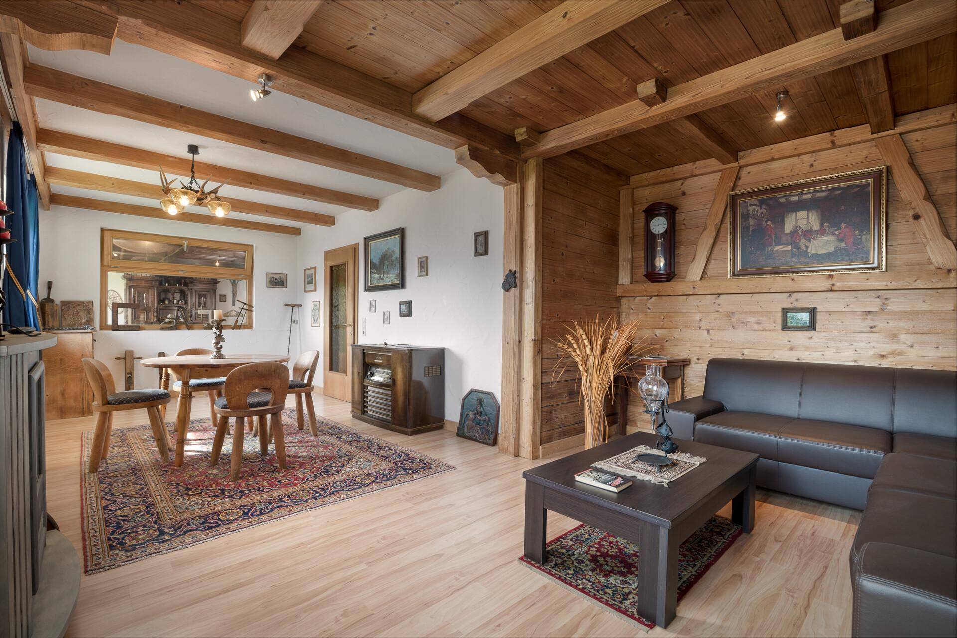 Heller Wohn- und Essbereich mit Holzvertäfelung, sichtbaren Balken und traditionellem Charme.