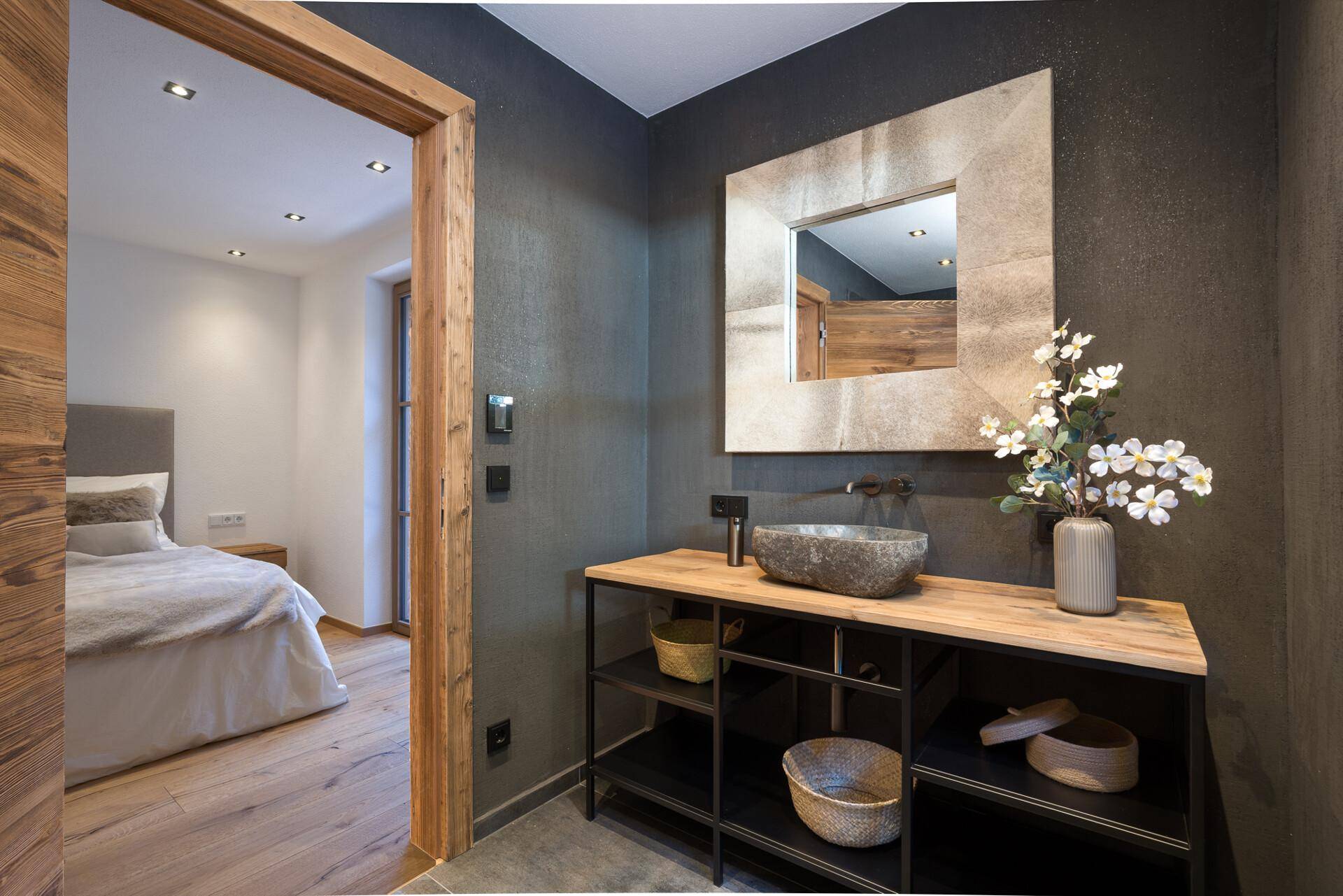 Stilvolles Badezimmer mit modernem Waschbecken, großem Spiegel und Holzakzenten.