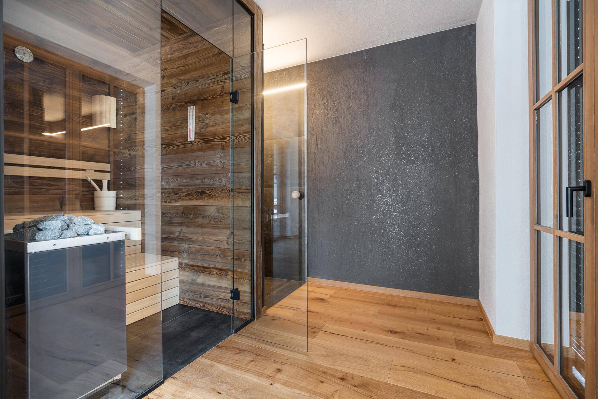 Moderner Wellnessbereich mit Sauna und Holzakzenten, verbunden mit einem hellen Flur.