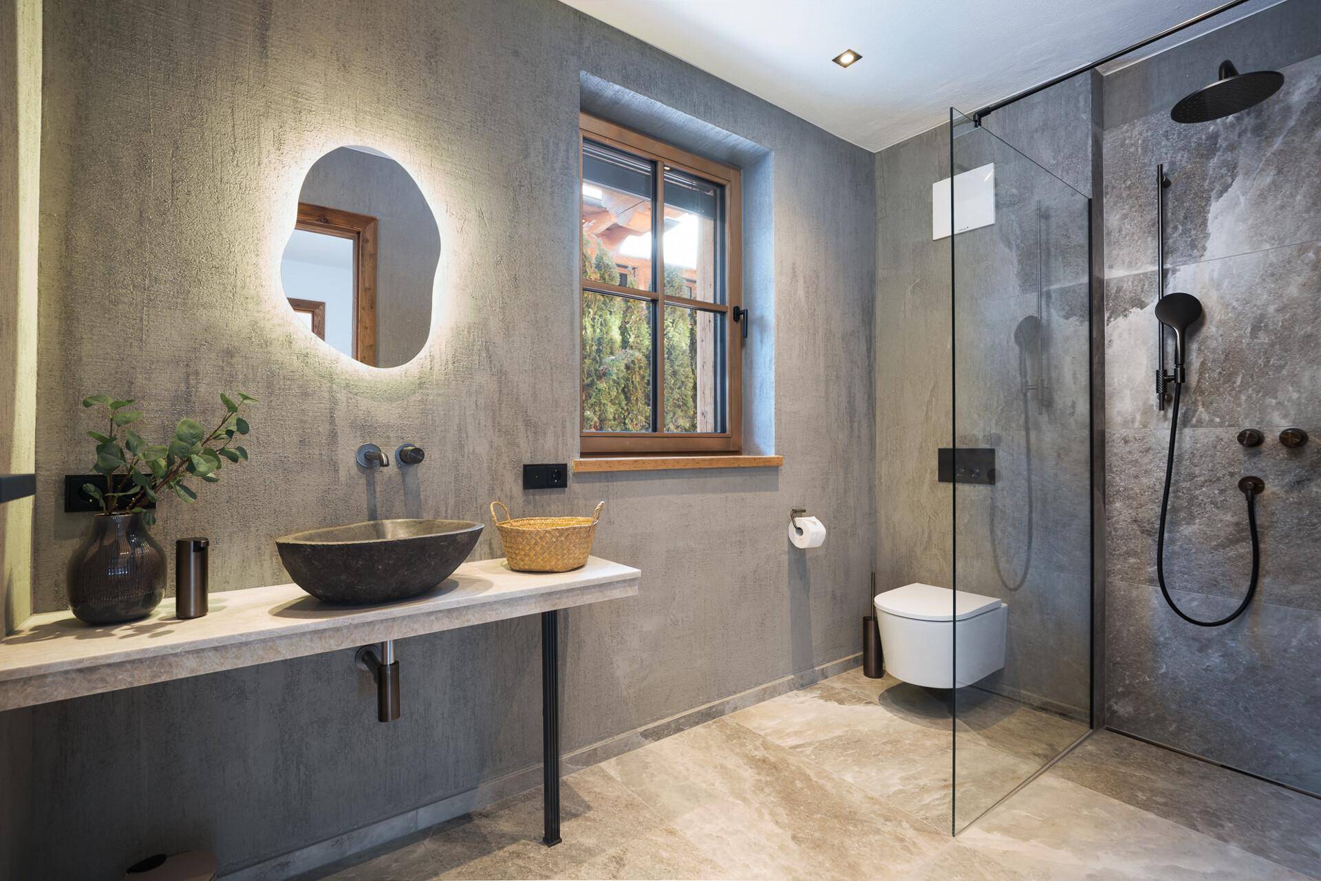 Elegantes Badezimmer mit großer begehbarer Dusche, Fenster und modernem Waschtisch mit Steinbecken.