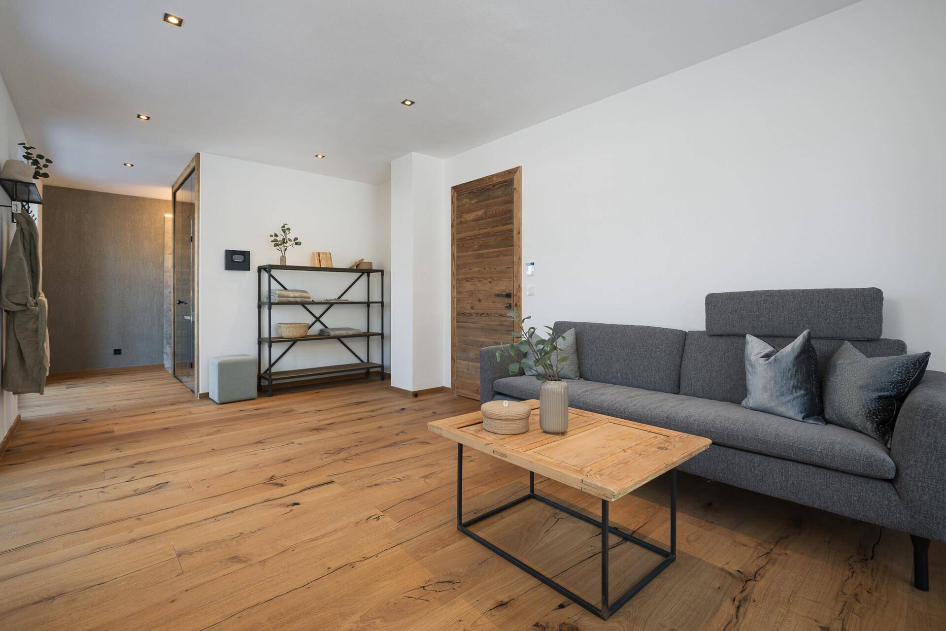Gemütlicher Wohnbereich mit bequemer Couch, Holzboden und moderner Einrichtung, perfekt zum Entspannen.