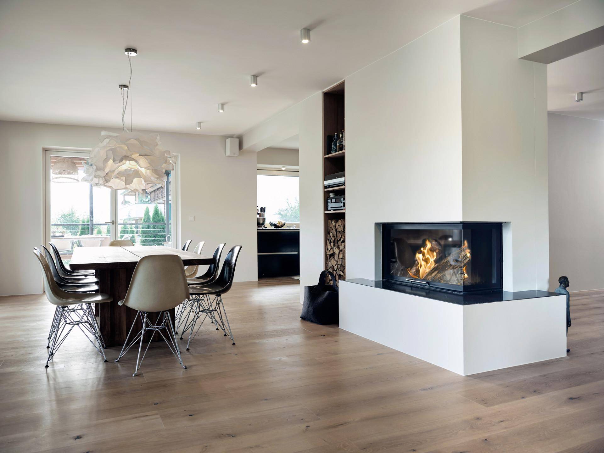 Geräumiger Wohn-Essbereich mit modernem Kamin, Holzboden und stilvoller Einrichtung.