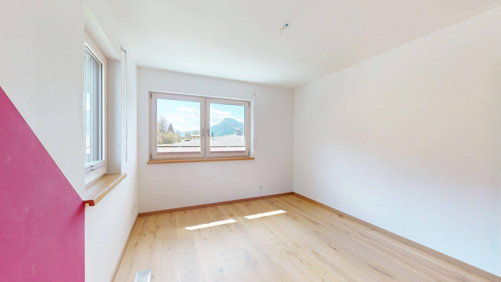 Geräumiges Schlafzimmer mit Holzboden und hellen Wänden, bereit zur individuellen Gestaltung.