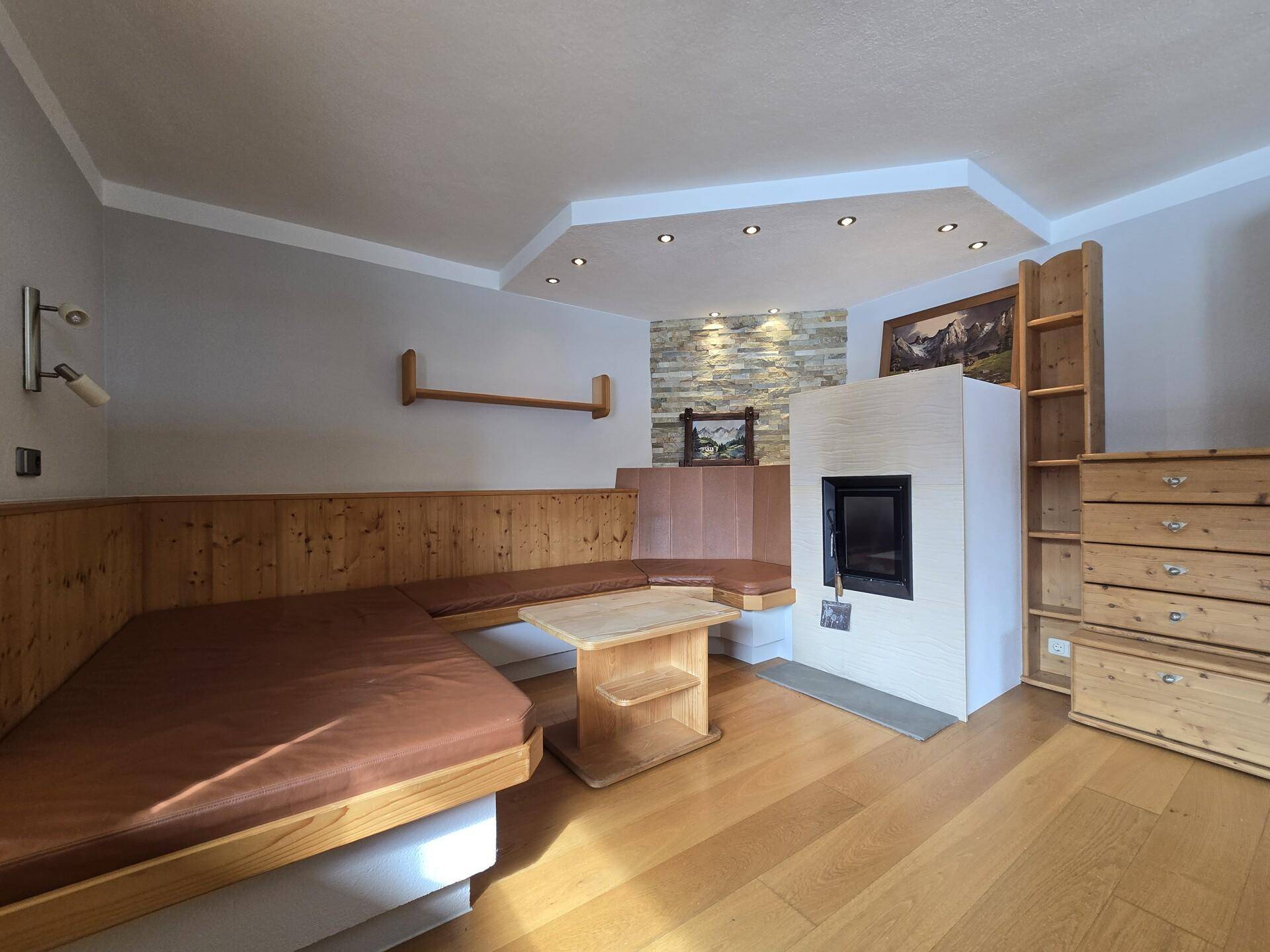 Gemütliches Wohnzimmer im Alpenstil mit Holzbänken und modernem Kamin.