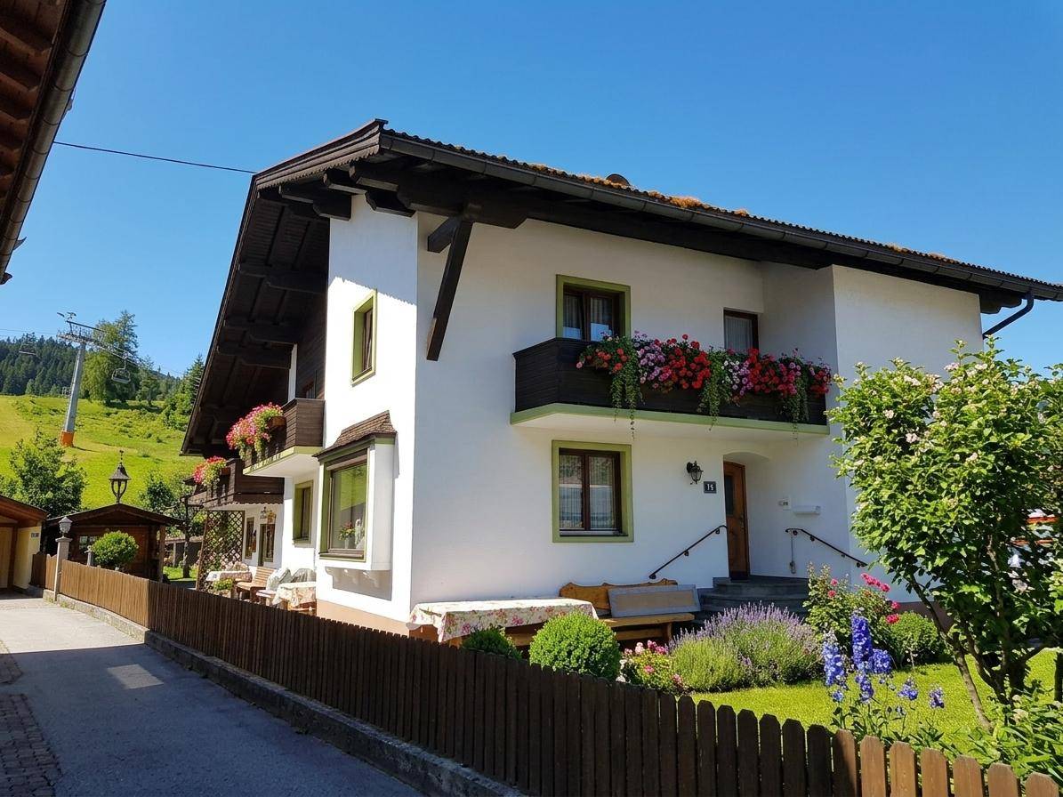 Charmantes Haus im alpinen Stil mit blühenden Balkonen und gepflegtem Vorgarten in sonniger Lage.