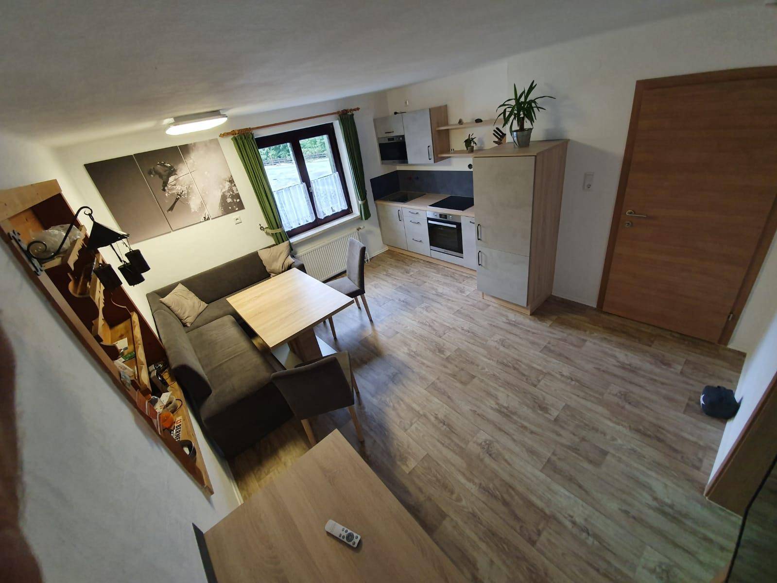 Geräumige Wohnküche mit moderner Ausstattung, Essbereich und Sofa in offenem Grundriss.