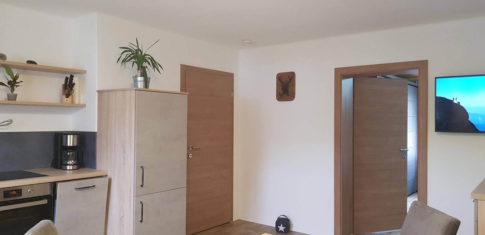 Moderne Küchenzeile mit hellen Schränken und integrierten Geräten, offen gestaltet.
