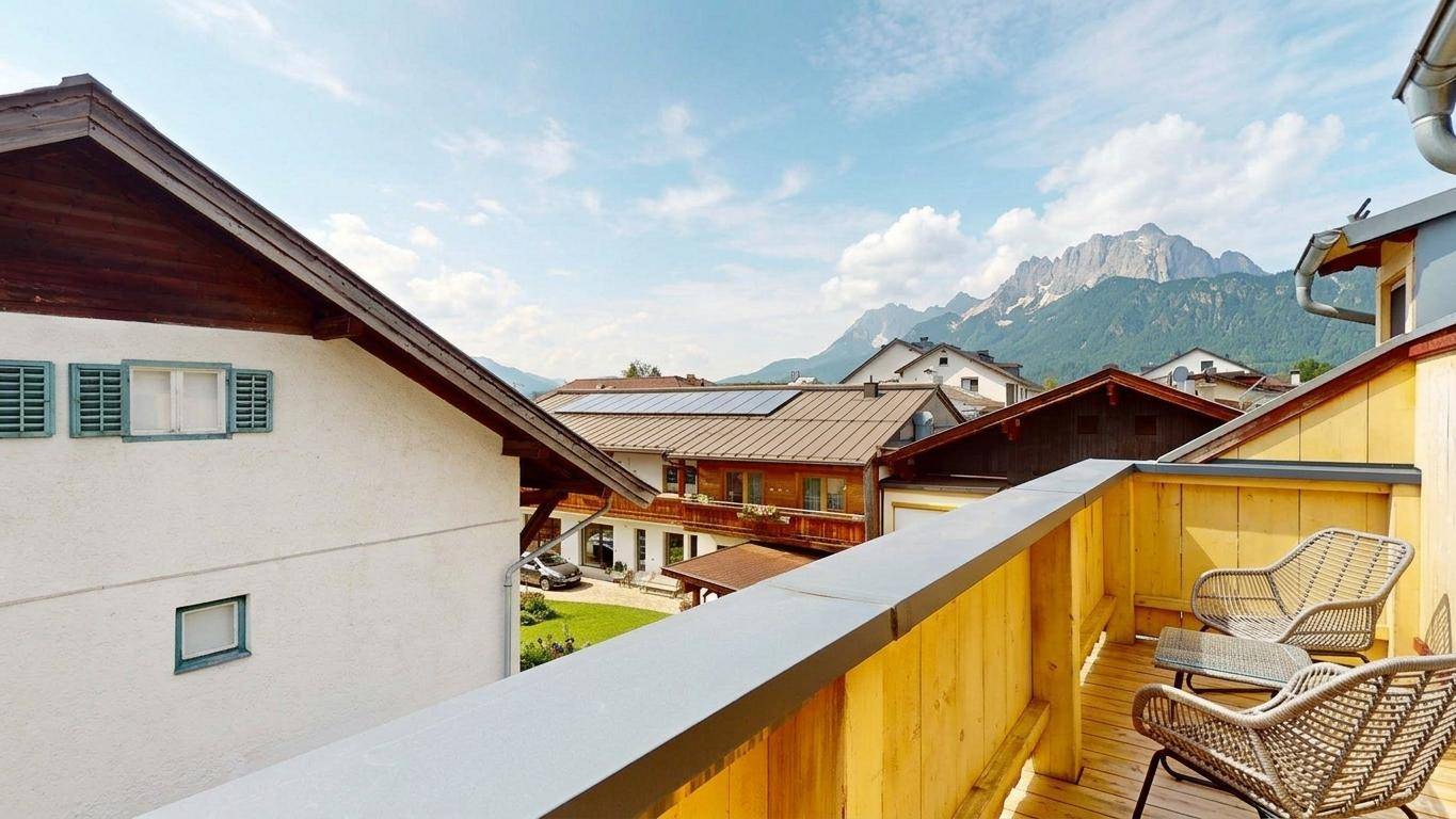 Balkon mit Sitzgelegenheiten und einem atemberaubenden Blick auf die umliegenden Berge.
