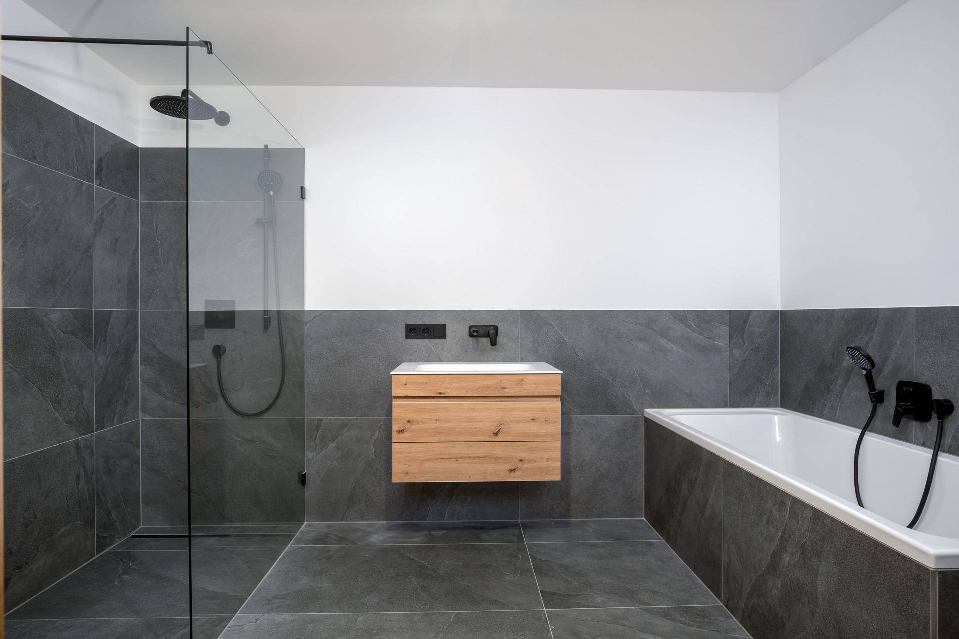 Elegantes Badezimmer mit begehbarer Dusche, Badewanne und modernem Holzwaschtisch.