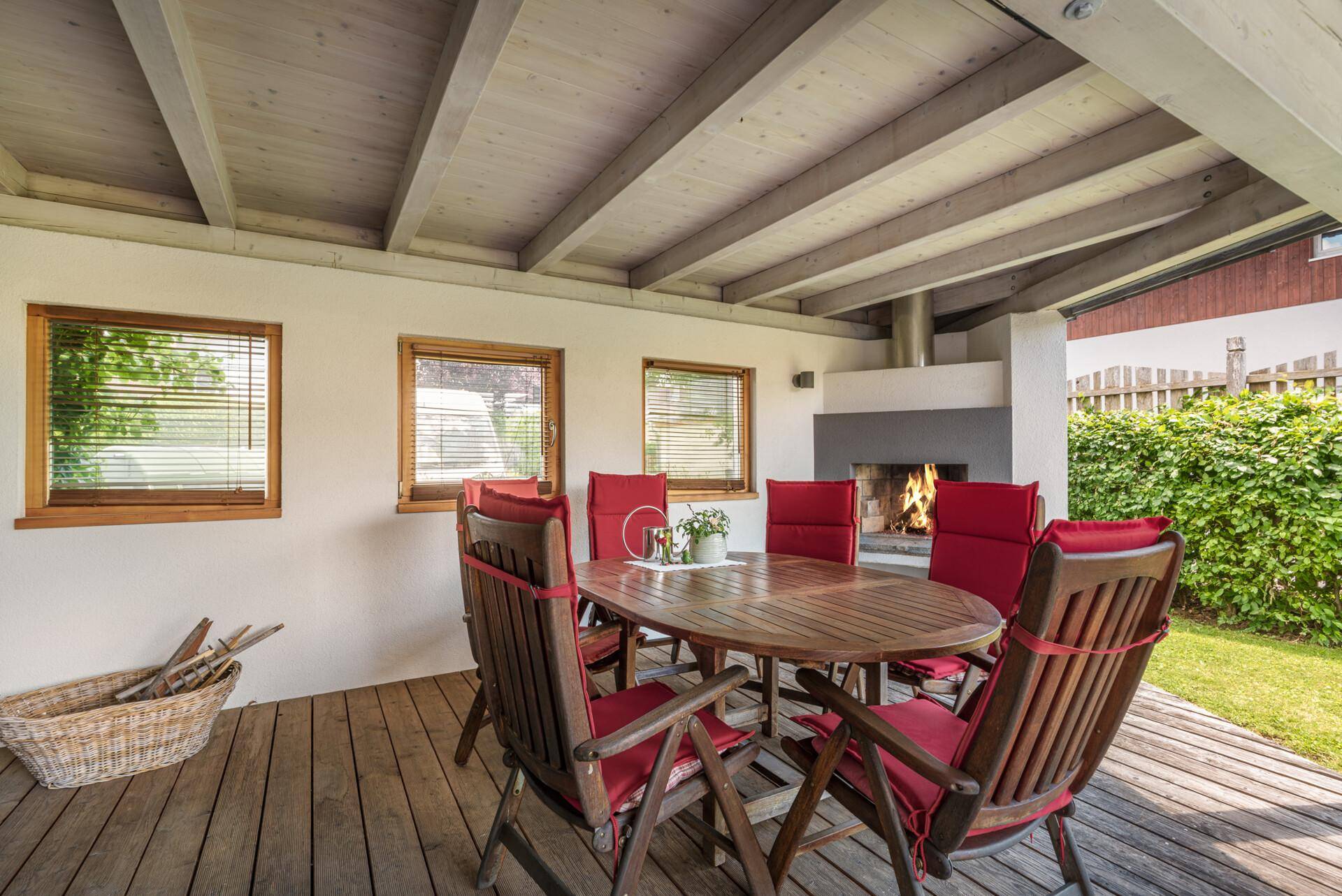 Überdachte Terrasse mit Esstisch, Stühlen und einem gemütlichen Außenkamin für entspannte Abende.