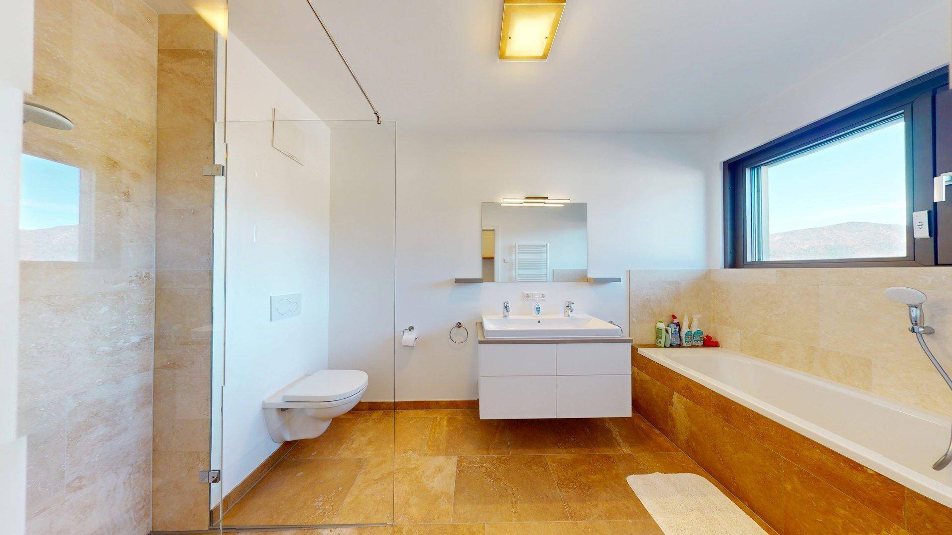 Modernes Badezimmer mit begehbarer Dusche, Badewanne, Doppelwaschbecken und Fenster.
