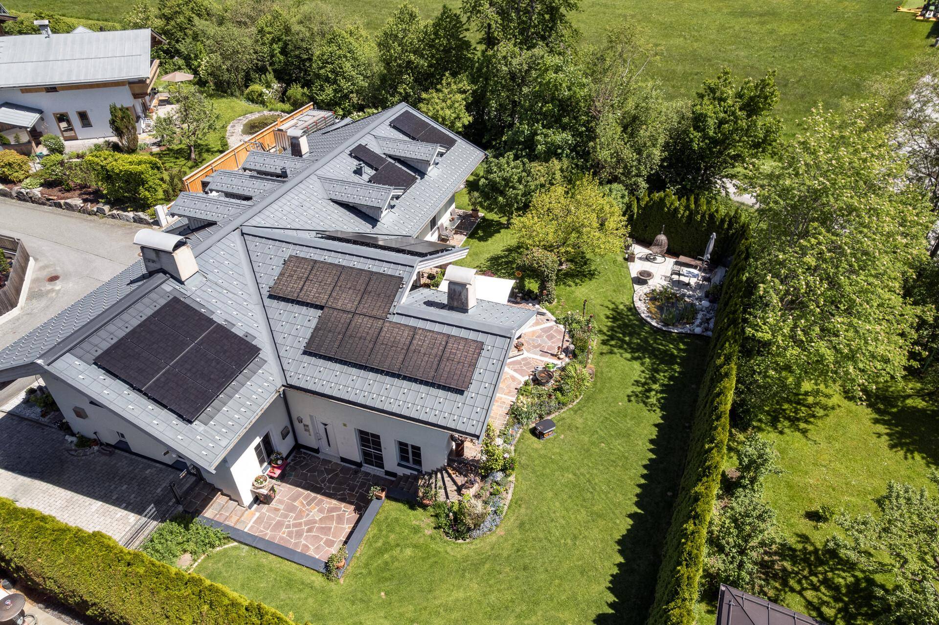 Vogelperspektive des Hauses mit Photovoltaikanlage, großem Garten und Zufahrt.