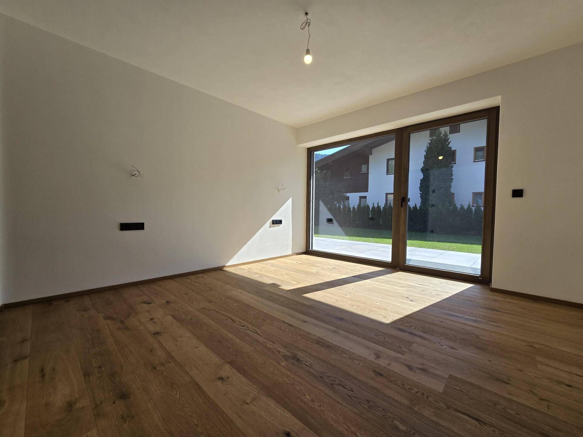 Heller Raum mit Eichenparkett und großer Schiebetür zum Garten oder zur Terrasse.