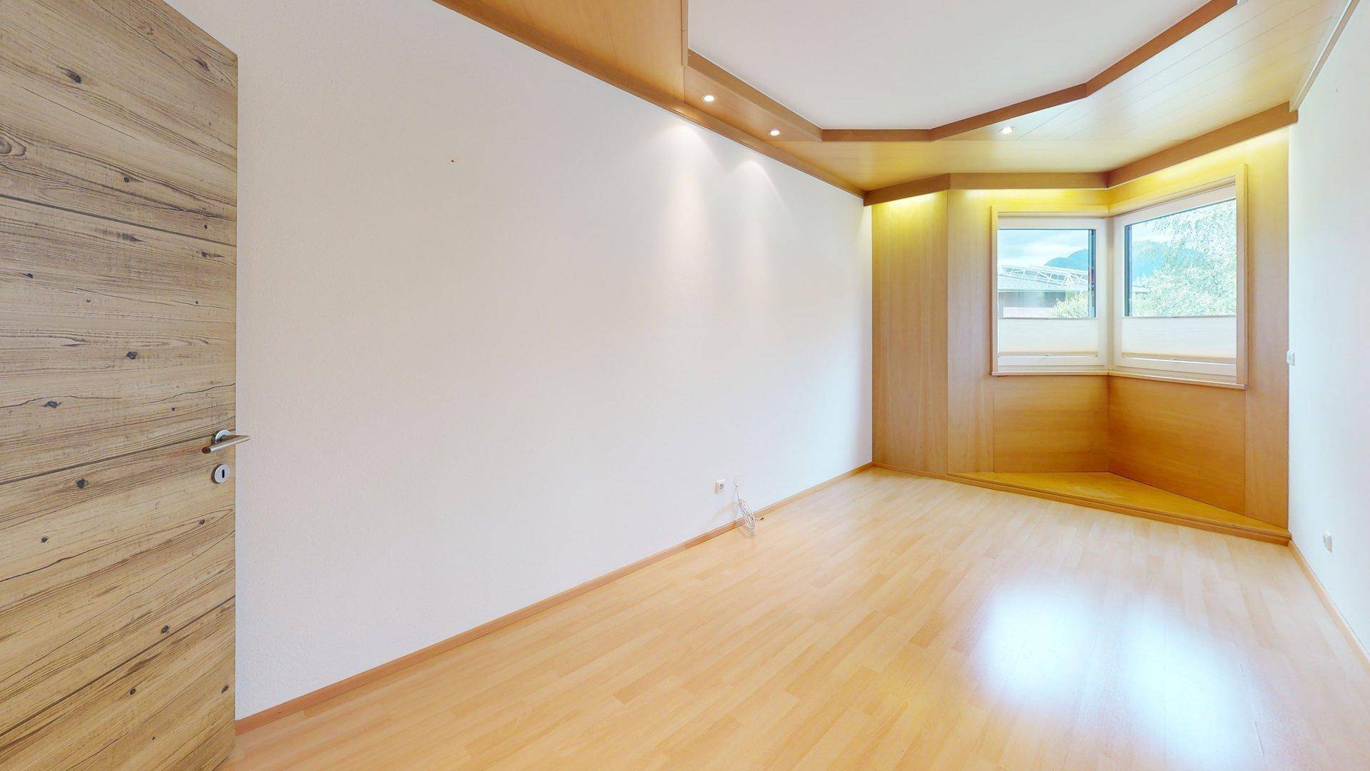 Helles Schlafzimmer mit Laminatboden, Holzdeckenverkleidung und einem charmanten Erkerfenster.