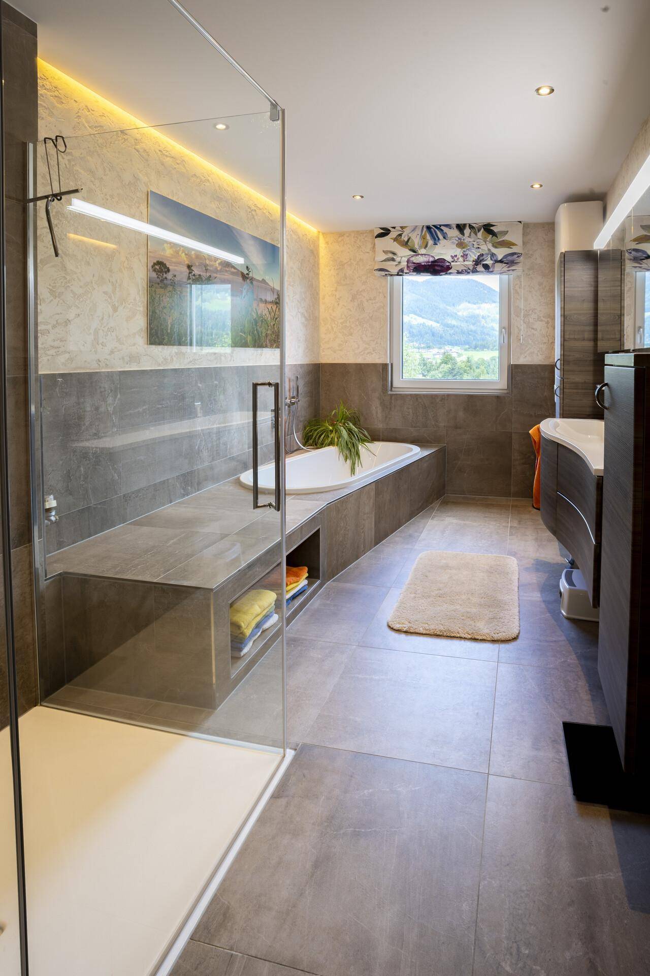 Modernes Badezimmer mit begehbarer Dusche, Badewanne, großformatigen Fliesen und Fenster.