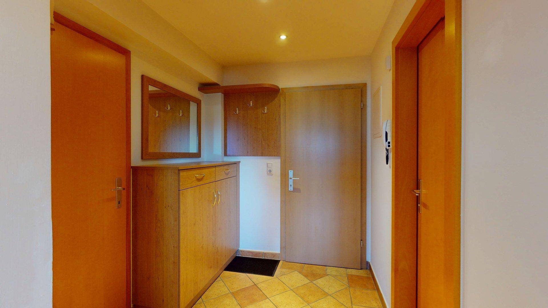 Eingangsbereich mit Fliesenboden, Garderobe und praktischem Schuhschrank.