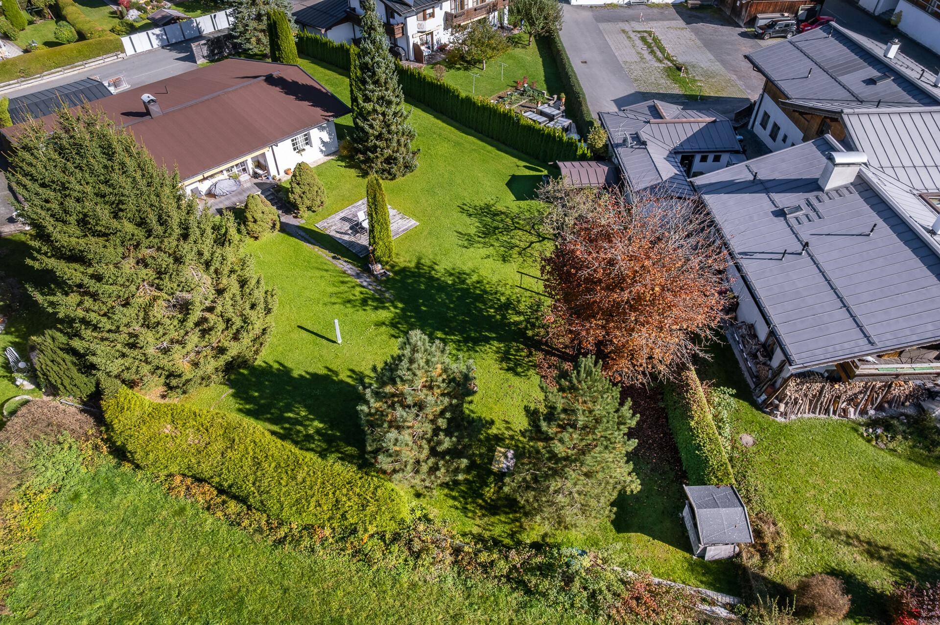 Luftaufnahme des Anwesens mit großem Garten, umgeben von weiteren Wohnhäusern und viel Grünfläche.
