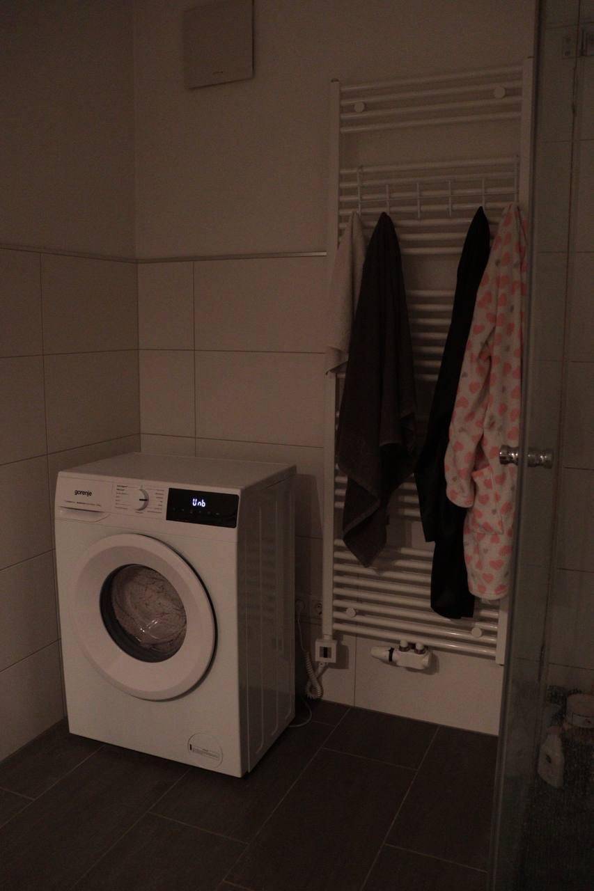 Hauswirtschaftsraum mit Waschmaschine und beheiztem Handtuchhalter, praktisch und funktional eingerichtet.
