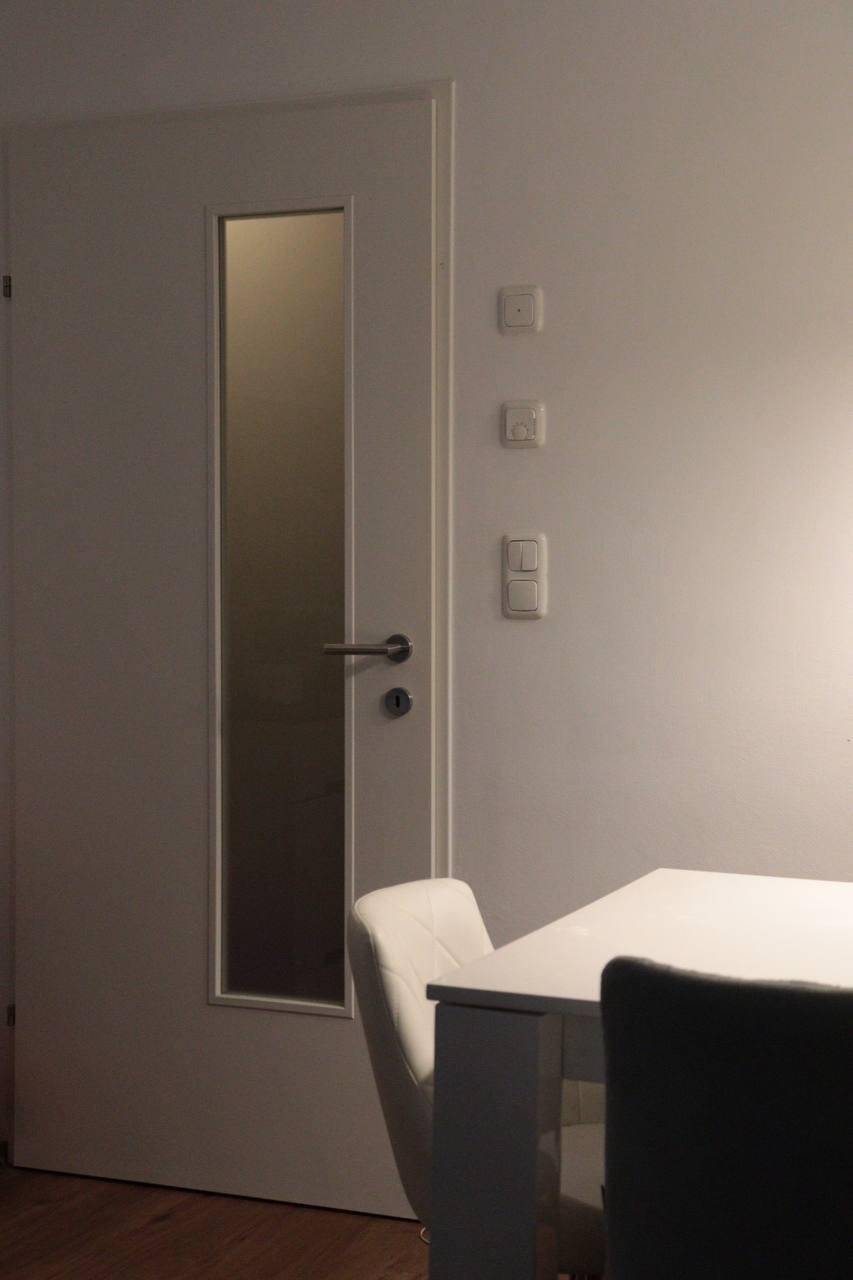 Weiße Innentür mit Milchglas-Einsatz neben einem Essbereich, die einen modernen Akzent setzt.