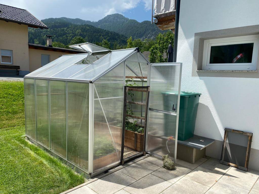 Gewächshaus im Gartenbereich neben dem Haus, ideal für den Anbau von Pflanzen.