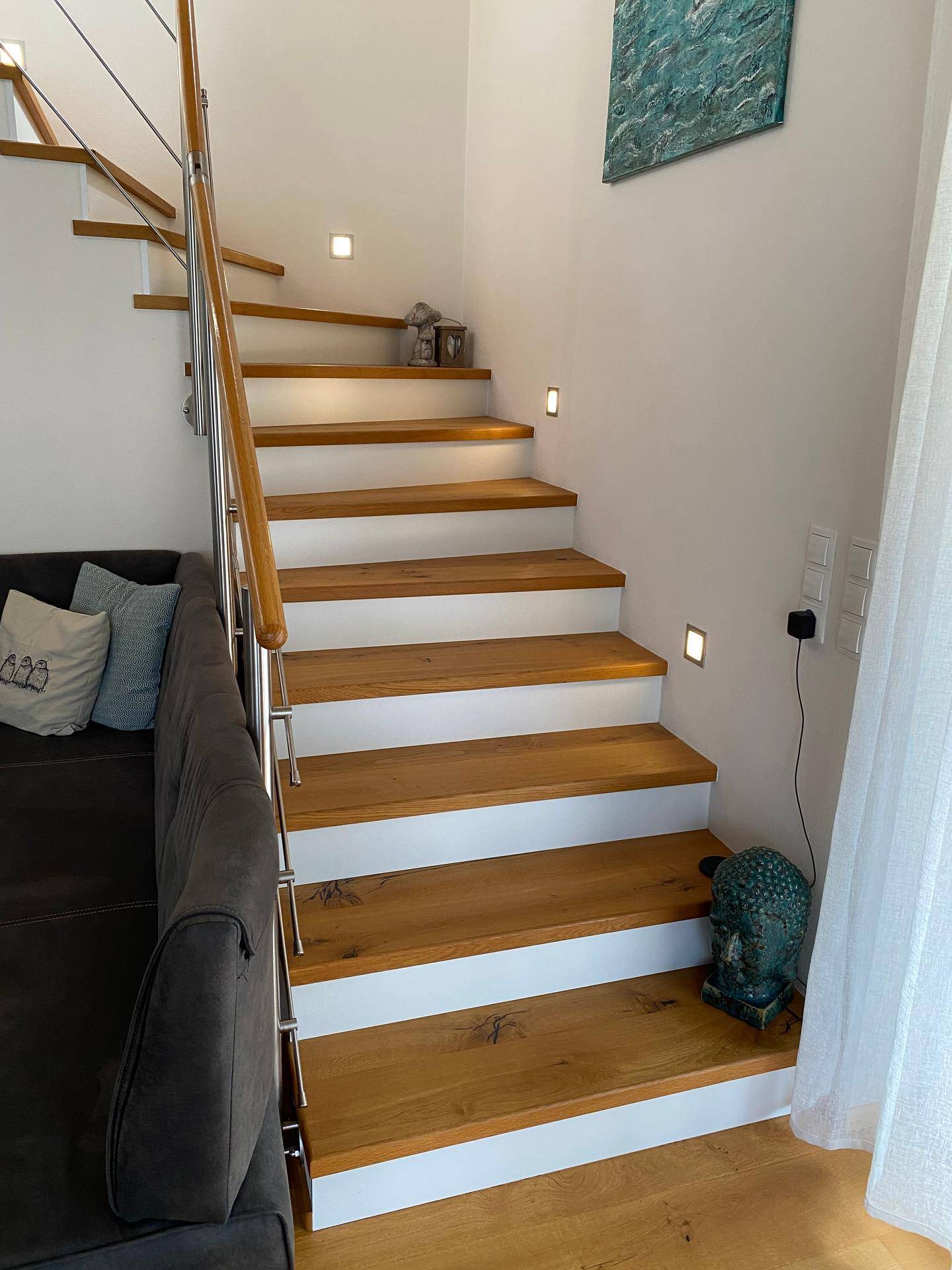 Moderne Holztreppe mit integrierter Beleuchtung, die die oberen Etagen verbindet.